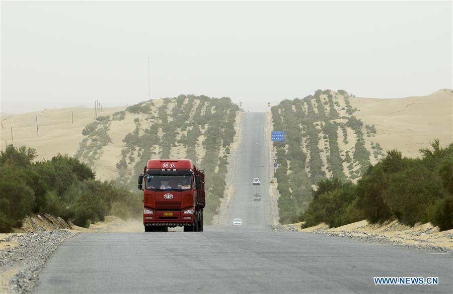 Cars run on the first highway in Taklimakan Desert in northwest China\'s Xinjiang Uygur Autonomous Region, June 12, 2018. The first highway across the Taklimakan, running 522 kilometers from Lunnan in the north, to Minfeng county in the south, was opened to traffic in 1995. The second north-south road across the desert opened to traffic about a decade ago, cutting the distance between the two important regional cities of Hotan and Aral by 550 km and the travel time by about seven hours. (Xinhua/Zhao Ge)