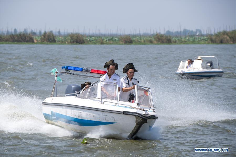Staff members of the Xiaogang lake-patroller station patrol the Honghu Lake in Honghu City, central China\'s Hubei Province, Aug. 15, 2018. Honghu Lake, Hubei Province\'s biggest lake, is \