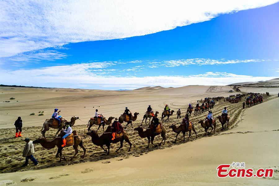 <?php echo strip_tags(addslashes(Tourists visit the Mingsha Hill scenic spot in the Gobi desert in Dunhuang City, Northwest China's Gansu Province, Aug. 15, 2018. Consisting of a group of sand dunes, the Mingsha Hill, or 