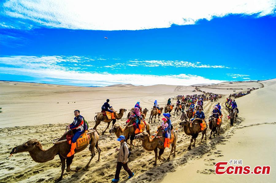 <?php echo strip_tags(addslashes(Tourists visit the Mingsha Hill scenic spot in the Gobi desert in Dunhuang City, Northwest China's Gansu Province, Aug. 15, 2018. Consisting of a group of sand dunes, the Mingsha Hill, or 