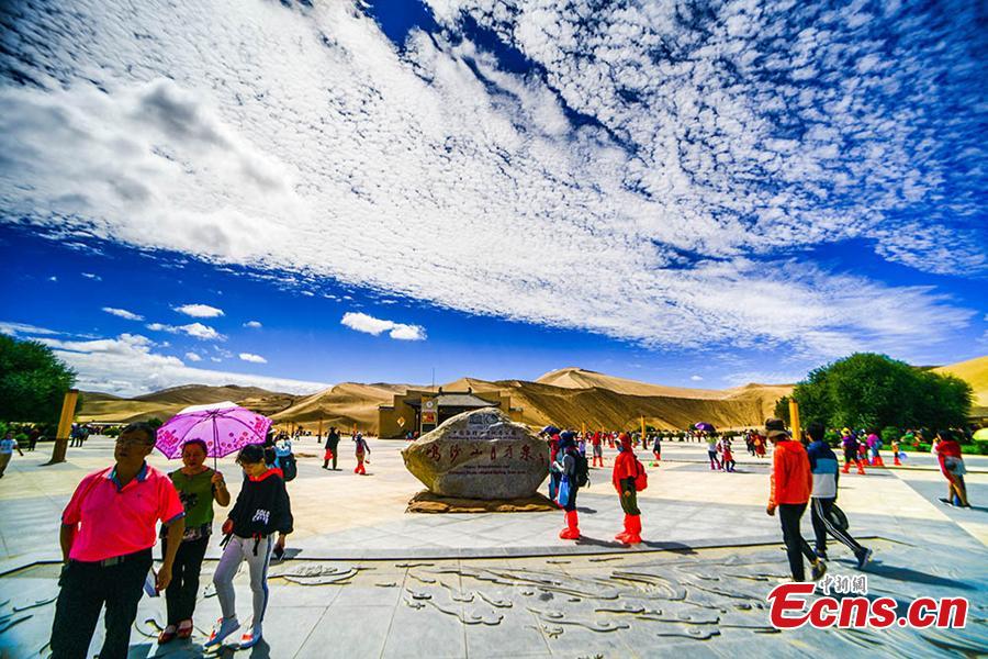 Tourists visit the Mingsha Hill scenic spot in the Gobi desert in Dunhuang City, Northwest China\'s Gansu Province, Aug. 15, 2018. Consisting of a group of sand dunes, the Mingsha Hill, or \