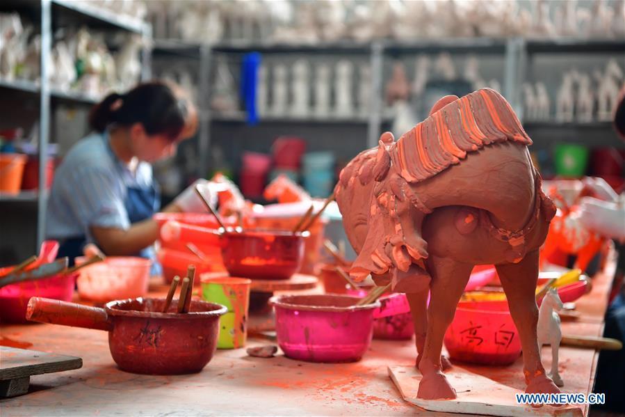 <?php echo strip_tags(addslashes(An artisan works at a workshop of Gao Shuiwang, a tri-colored glazed pottery technique inheritor, in Nanshishan Village, Mengjin County, Luoyang City, central China's Henan Province, Aug. 15, 2018. Gao is a leading figure in the revival of tri-colored glazed pottery, or Sancai, a Chinese porcelain characterized by a glaze with three intermingled colours. The producing technique of Sancai, which flourished in the Tang Dynasty (618-907 AD), was very complex and listed as one of China's National Intangible Heritages in 2008. Nanshishan Village in Henan is regarded as an important village of Sancai culture, with more than 70 enterprises now engaging in the industry. (Xinhua/Feng Dapeng))) ?>