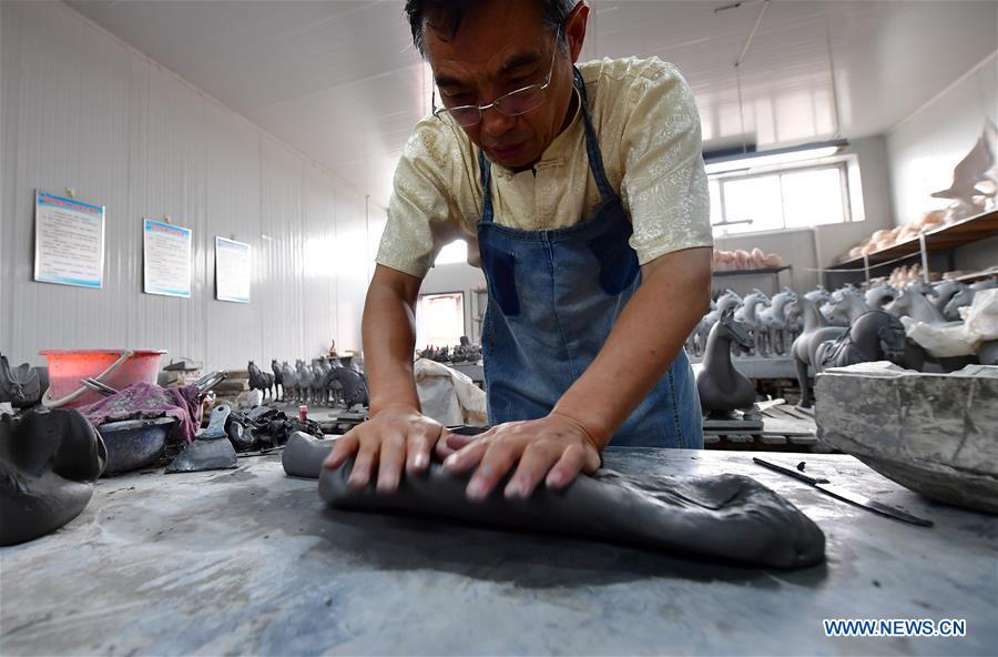 <?php echo strip_tags(addslashes(Tri-colored glazed pottery technique inheritor Gao Shuiwang makes clay for potteries in Nanshishan Village, Mengjin County, Luoyang City, central China's Henan Province, Aug. 15, 2018. Gao is a leading figure in the revival of tri-colored glazed pottery, or Sancai, a Chinese porcelain characterized by a glaze with three intermingled colours. The producing technique of Sancai, which flourished in the Tang Dynasty (618-907 AD), was very complex and listed as one of China's National Intangible Heritages in 2008. Nanshishan Village in Henan is regarded as an important village of Sancai culture, with more than 70 enterprises now engaging in the industry. (Xinhua/Feng Dapeng))) ?>