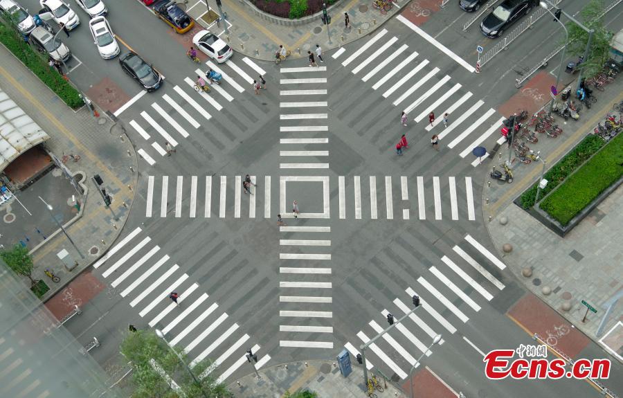 A new pedestrian crossing layout at the intersection of Lugu West Road and Zhengda Road in Shijiangshan District, Beijing, Aug. 19, 2018. When given the green light, pedestrians can choose to cross the intersection diagonally to get to the opposite corner in addition to simply crossing from one side of the road to the other. It is believed to be the first intersection with such an option for pedestrians in Beijing. (Photo: China News Service/Jia Tianyong)