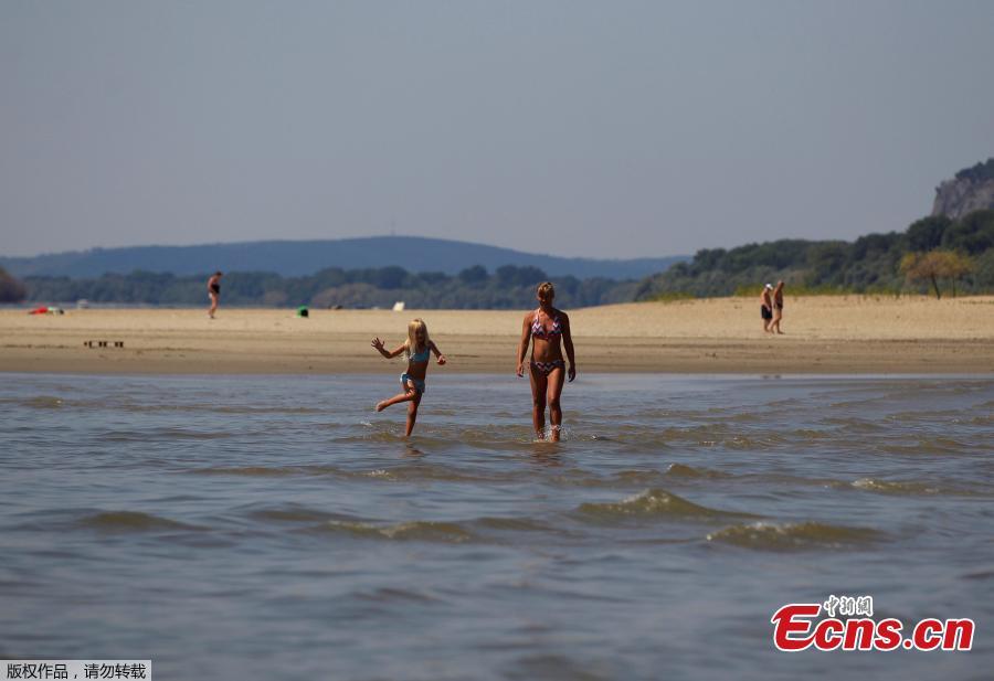 People walk in the middle of the Danube river during the period of low water level near Esztergom, Hungary, August 19, 2018. (Photo/Agencies)