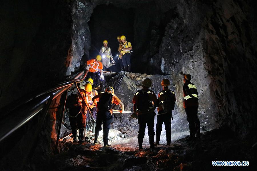 Staff members climb down a stone wall while patrolling the Yindongpo Tunnel of Guizhou-Guangxi Railway in Duyun City, southwest China\'s Guizhou Province, Aug. 20, 2018. Railway maintenance workers here patrolled the 8.5-kilometer tunnel and took necessary measures to ensure the safety of railway transportation during the flood season. (Xinhua/Liu Xu)