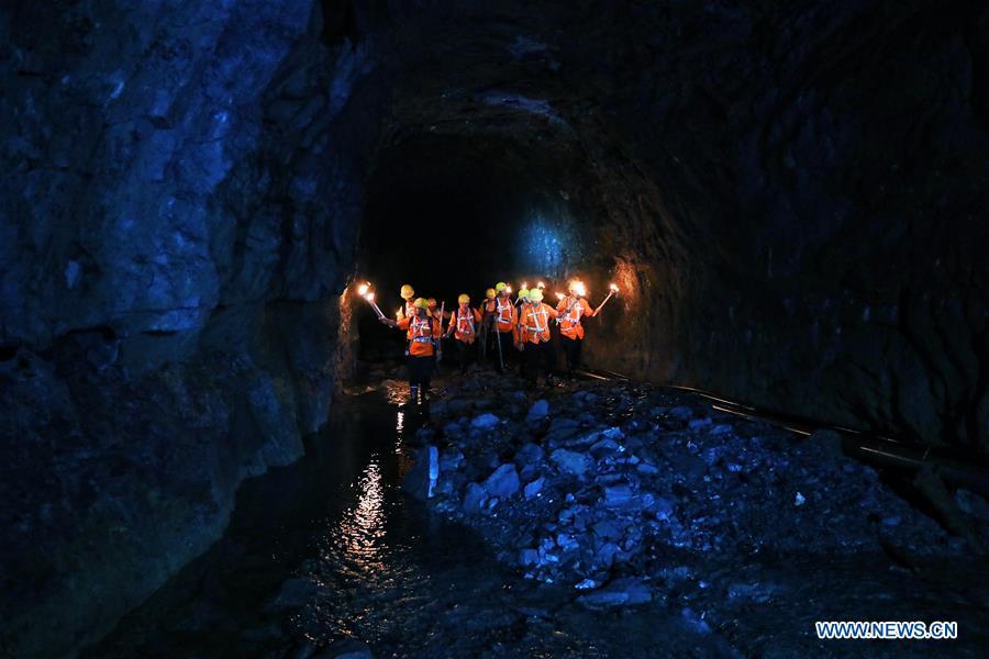 Staff members check the wall of Yindongpo Tunnel of Guizhou-Guangxi Railway with the light from torches in Duyun City, southwest China\'s Guizhou Province, Aug. 20, 2018. Railway maintenance workers here patrolled the 8.5-kilometer tunnel and took necessary measures to ensure the safety of railway transportation during the flood season. (Xinhua/Liu Xu)