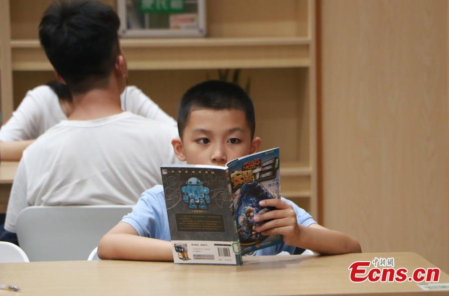People read books at the newly-opened West Lake Bookstore in Hangzhou City, East China’s Zhejiang Province, Aug. 20, 2018. Hangzhou residents can access the unmanned bookstore, and borrow or return books all by swiping their IDs. Non-Hangzhou residents still need a conventional library card. (Photo: China News Service/Liu Peiqi)