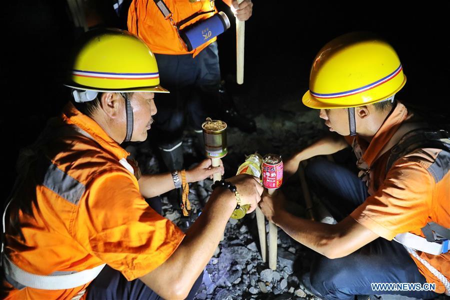 Staff members light up torches to patrol the Yindongpo Tunnel of Guizhou-Guangxi Railway in Duyun City, southwest China\'s Guizhou Province, Aug. 20, 2018. Railway maintenance workers here patrolled the 8.5-kilometer tunnel and took necessary measures to ensure the safety of railway transportation during the flood season. (Xinhua/Liu Xu)