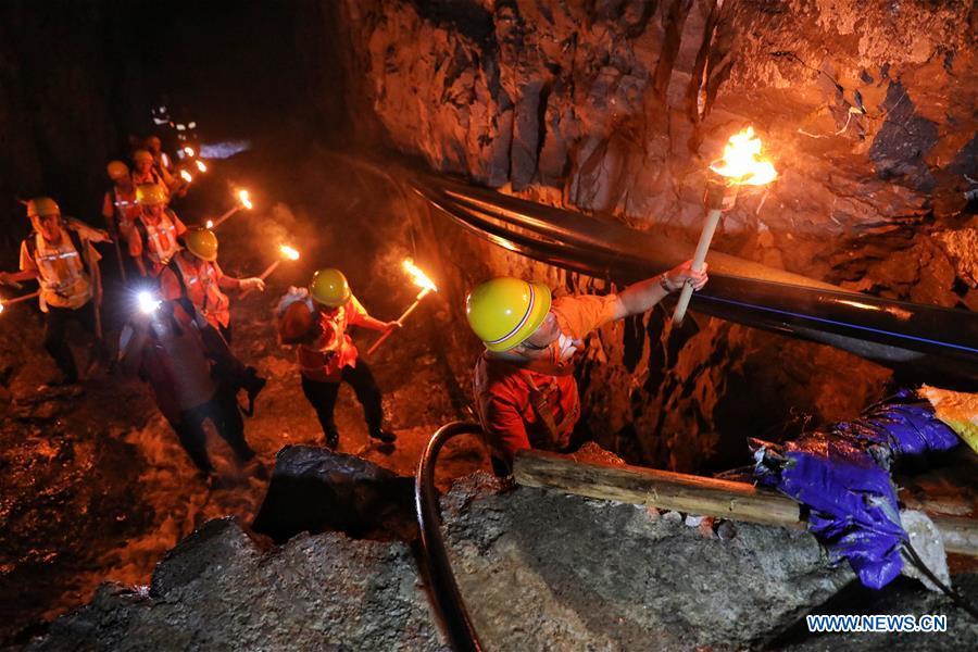 Staff members check the wall of Yindongpo Tunnel of Guizhou-Guangxi Railway with the light from torches in Duyun City, southwest China\'s Guizhou Province, Aug. 20, 2018. Railway maintenance workers here patrolled the 8.5-kilometer tunnel and took necessary measures to ensure the safety of railway transportation during the flood season. (Xinhua/Liu Xu)