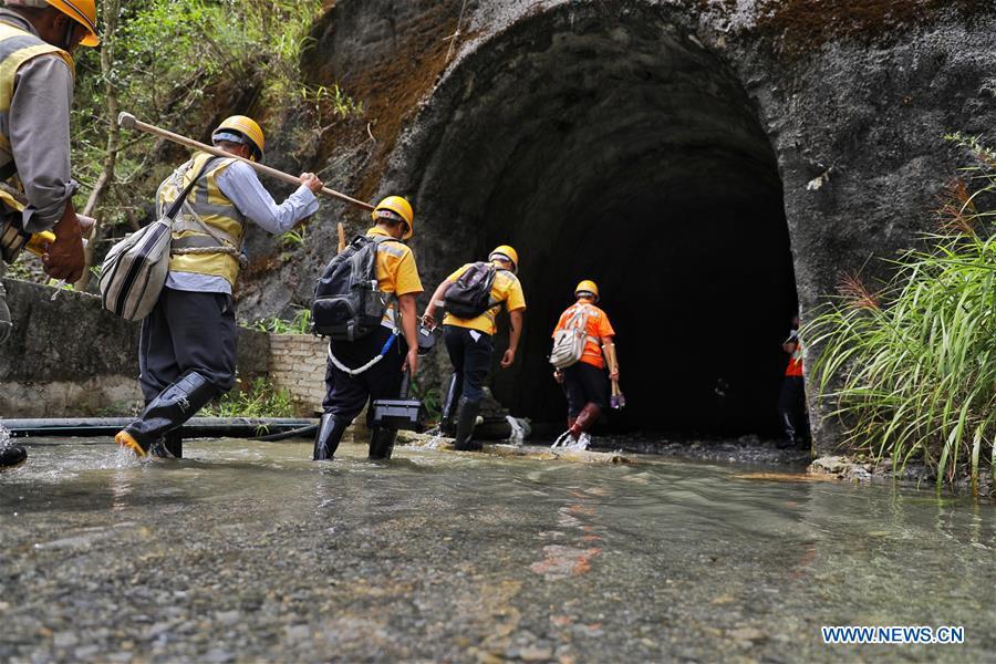 Staff members check the wall of Yindongpo Tunnel of Guizhou-Guangxi Railway with the light from torches in Duyun City, southwest China\'s Guizhou Province, Aug. 20, 2018. Railway maintenance workers here patrolled the 8.5-kilometer tunnel and took necessary measures to ensure the safety of railway transportation during the flood season. (Xinhua/Liu Xu)