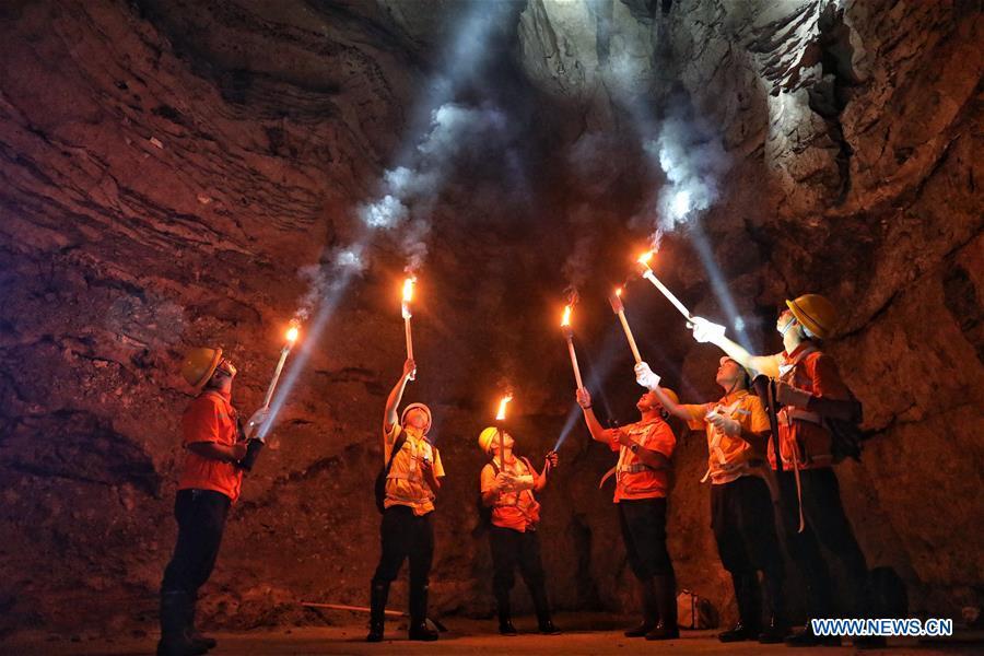Staff members check the wall of Yindongpo Tunnel of Guizhou-Guangxi Railway with torches in Duyun City, southwest China\'s Guizhou Province, Aug. 20, 2018. Railway maintenance workers here patrolled the 8.5-kilometer tunnel and took necessary measures to ensure the safety of railway transportation during the flood season. (Xinhua/Liu Xu)