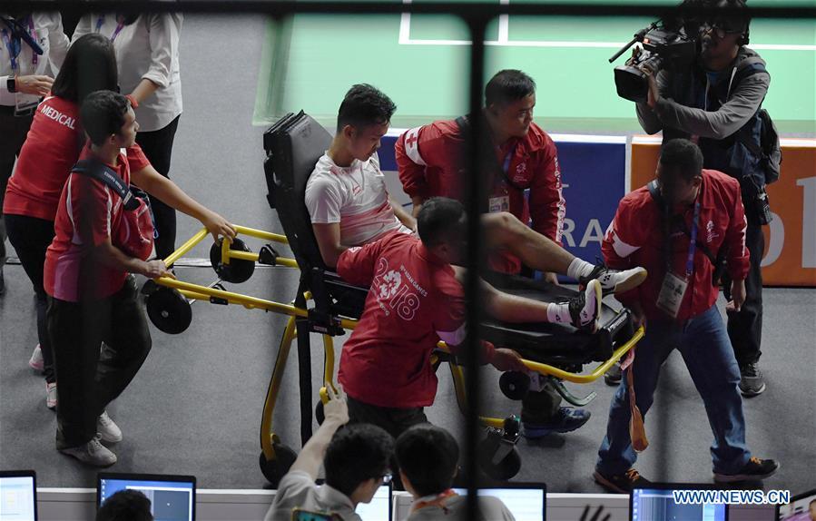Indonesia\'s Anthony Sinisuka is wheeled away after he is injured in the singles match of men\'s team final between China and Indonesia at the 18th Asian Games in Jakarta, Indonesia on Aug. 22, 2018. (Xinhua/Li Xiang)