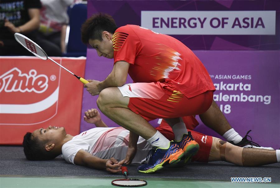 China\'s Shi Yuqi comes over as Indonesia\'s Anthony Sinisuka lies on the ground during the singles match of men\'s team final between China and Indonesia at the 18th Asian Games in Jakarta, Indonesia on Aug. 22, 2018. (Xinhua/Li Xiang)