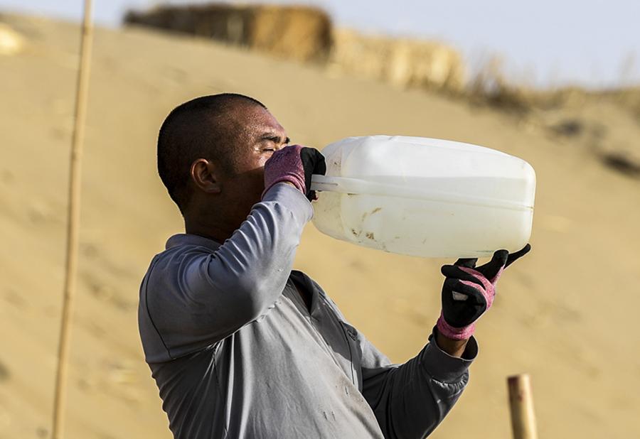 <?php echo strip_tags(addslashes(A worker drinks water during the break.  (Photo/Xinhua) <br><br>

This new road, however, could be his toughest project yet. Working for 10 hours a day, he makes hundreds of trips between dunes, digging up to 2,000 cubic meters of sand.<br><br>

Towers of sand<br><br>

More than a half of China's total desert area is in Xinjiang. Roads such as the one being built by Zhang and his colleagues are essential, making it easier for residents and goods to travel through these areas.<br><br>

The first highway across the Taklimakan was opened to traffic in 1995 and runs north to south from Lunnan town to Minfeng county. At 522 km, it is the world's longest desert highway.)) ?>