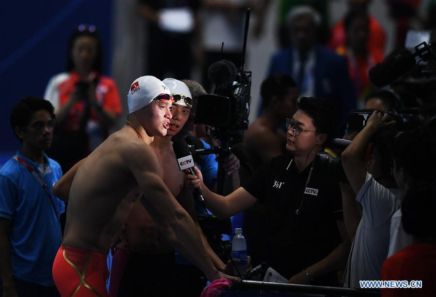 <?php echo strip_tags(addslashes(Sun Yang (L front) of China gets interviewed after men's 1500m freestyle final of swimming at the 18th Asian Games in Jakarta, Indonesia, Aug. 24, 2018. Sun won the gold medal. (Xinhua/Yue Yuewei))) ?>