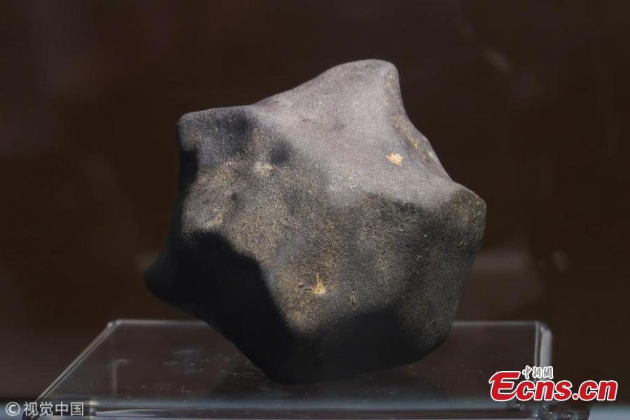 Photo taken on Aug. 25, 2018 shows a meteorite exhibited at a press conference held by Shanghai Planetarium in east China\'s Shanghai. Shanghai Planetarium on Saturday announced plans to house meteorites recovered from a meteor fireball that happened over the sky in Jinghong City of southwest China\'s Yunnan Province in June. The planetarium, which is under construction, will be a branch of the Shanghai Science & Technology Museum. The museum staff have successfully recovered more than 500 pieces of meteorites, about 50 kg in total, said Lin Qing, deputy director in charge of the planetarium construction, at a press conference Saturday. (Photo/VCG)