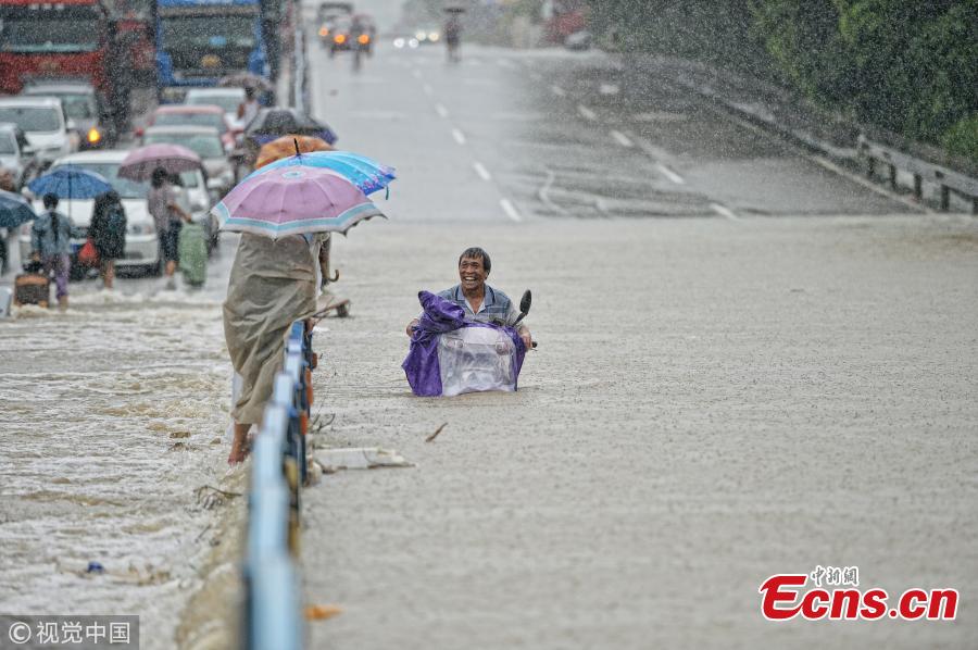 A motorcyclist drives on a flooded road after a rainstorm in Quanzhou City, East China’s Fujian Province, Aug. 29, 2018. (Photo/VCG)