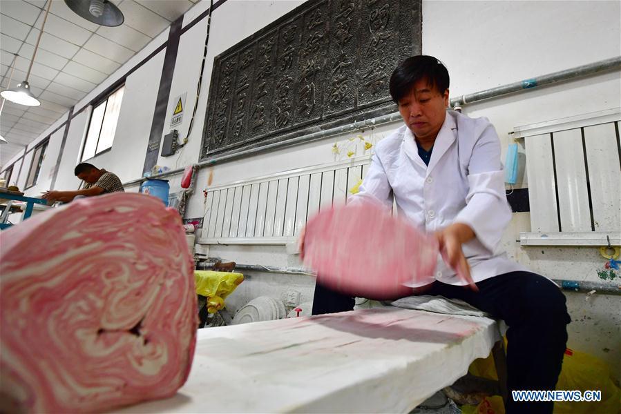 Chai Zhanzhu, the representative inheritor of Dangyangyu kiln Jiao Tai pottery firing, processes the clay at Dangyangyu Village of Xiuwu County in Jiaozuo, central China\'s Henan Province, Aug, 27, 2018. The Dangyangyu kiln Jiao Tai pottery firing is a handicraft that was listed as a national intangible cultural heritage in 2014. The Jiao Tai pottery is made by blending clays of differing colours together, creating distinctive veined or mottled patterns. The handicraft is therefore recognized as \