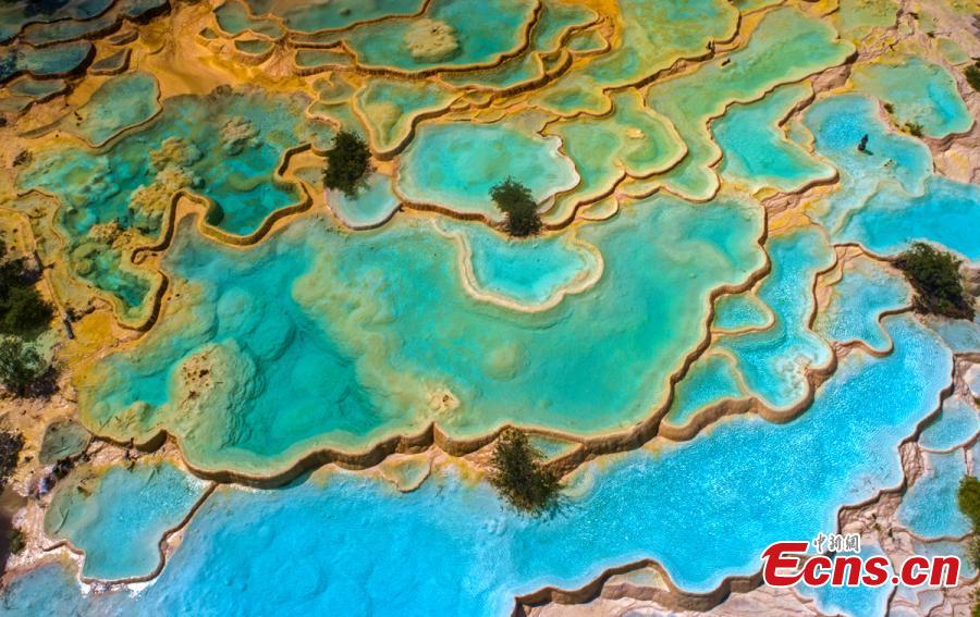 An aerial view of the Huanglong scenic area in Sichuan Province. A UNESCO World Heritage site, the area is known for its colorful pools formed by calcite deposits, especially in Huanglonggou (Yellow Dragon Gully), as well as diverse forest ecosystems, snow-capped peaks, waterfalls and hot springs. The Wucai Pond (Five-Colored Pond) is one of its top attractions. (Photo: China News Service/Yang Jian)