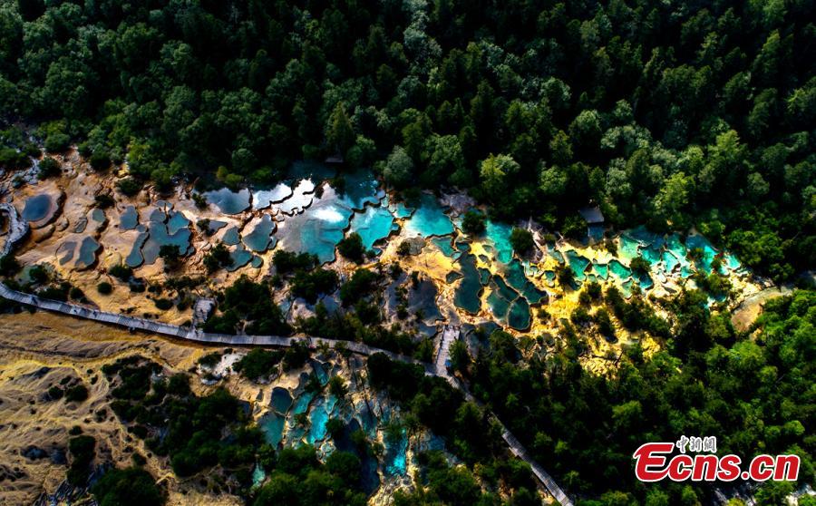 An aerial view of the Huanglong scenic area in Sichuan Province. A UNESCO World Heritage site, the area is known for its colorful pools formed by calcite deposits, especially in Huanglonggou (Yellow Dragon Gully), as well as diverse forest ecosystems, snow-capped peaks, waterfalls and hot springs. The Wucai Pond (Five-Colored Pond) is one of its top attractions. (Photo: China News Service/Yang Jian)