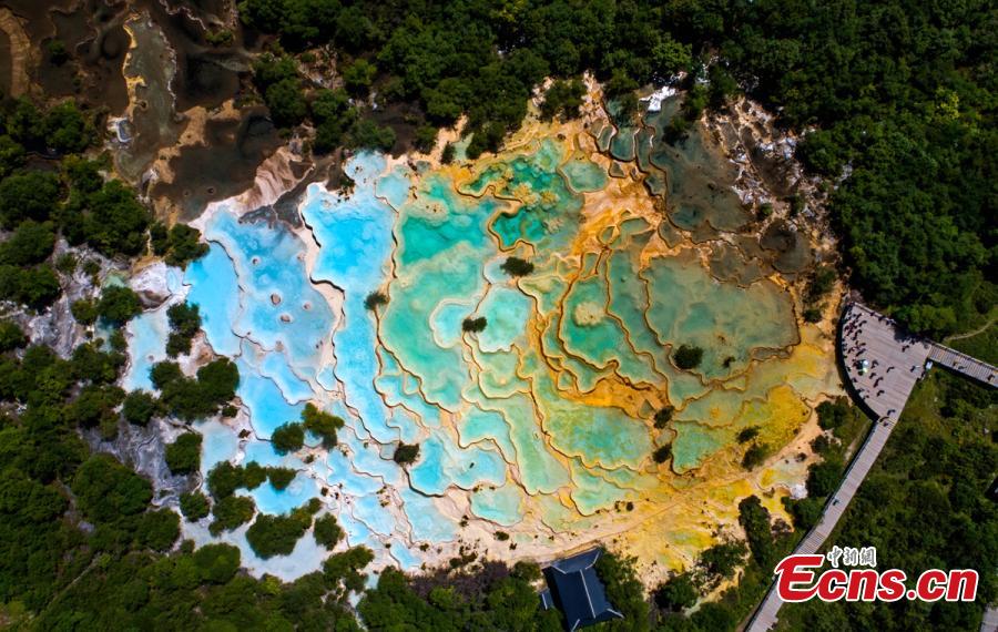 An aerial view of the Huanglong scenic area in Sichuan Province. A UNESCO World Heritage site, the area is known for its colorful pools formed by calcite deposits, especially in Huanglonggou (Yellow Dragon Gully), as well as diverse forest ecosystems, snow-capped peaks, waterfalls and hot springs. The Wucai Pond (Five-Colored Pond) is one of its top attractions. (Photo: China News Service/Yang Jian)