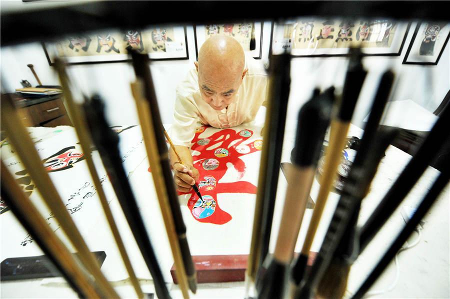 Zhao Xichun works on Peking Opera mask artwork in his workshop in Shaorao city, Jiangxi Province on Sept. 2, 2018. (Photo/Asianewsphoto)