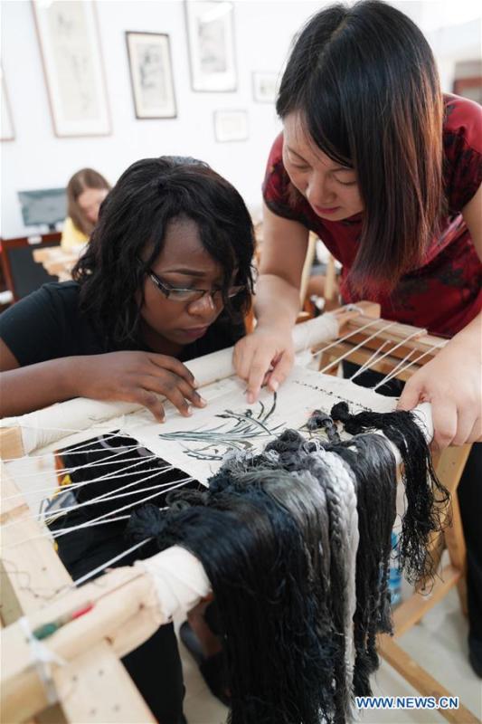 An African student learns embroidery under the coach of teacher Fu Aixiaing at Xinyu University in Xinyu, east China\'s Jiangxi Province, Sept. 5, 2018. The Xinyu university set up courses of embroidery and martial arts for African students to learn about Chinese culture as the new semester begins. (Xinhua/Song Zhenping)
