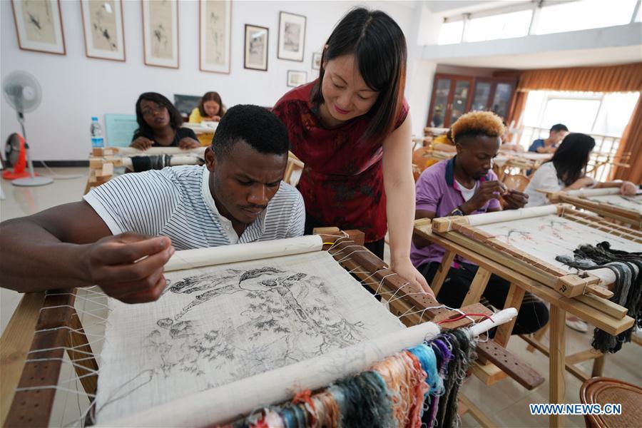 An African student learns embroidery under the coach of teacher Fu Aixiaing at Xinyu University in Xinyu, east China\'s Jiangxi Province, Sept. 5, 2018. The Xinyu university set up courses of embroidery and martial arts for African students to learn about Chinese culture as the new semester begins. (Xinhua/Song Zhenping)