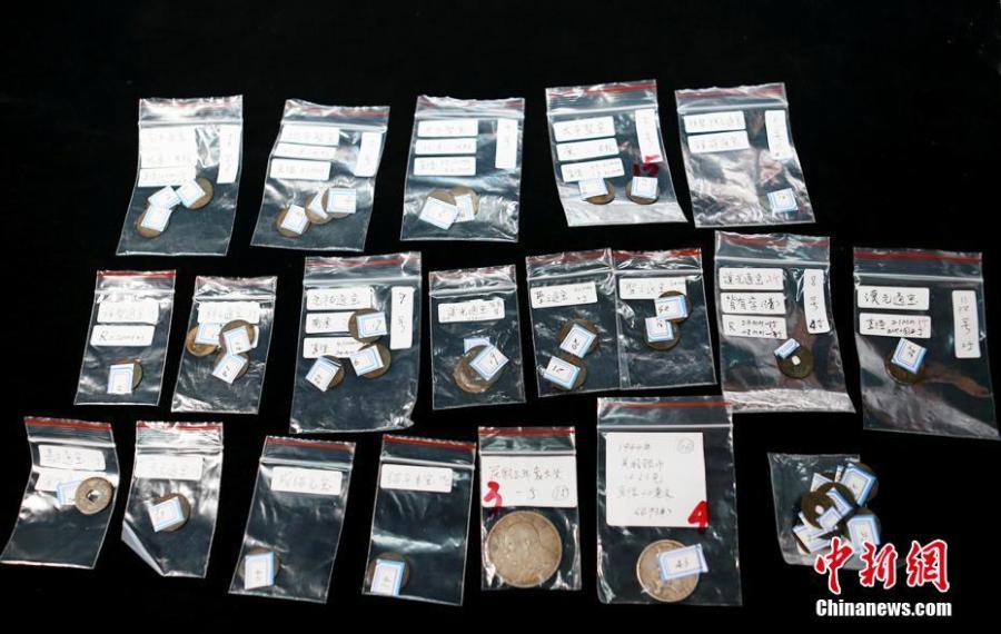 Customs officials show relics found in border checks at a handover ceremony in Guangdong Province, Sept. 6, 2018. Gongbei Customs handed over 157 cultural relics, including currency from the Warring States (475-221 B.C.) and Han Dynasty (206 BC ? 220 AD) periods, to Guangdong Provincial Cultural Relics Bureau. The relics were all Class I items under state protection and forbidden to be taken abroad. Among the findings was a well-preserved account book of the Qing Dynasty (1368-1644), thought to be of great historical value. (Photo: China News Service/Yu Bo)