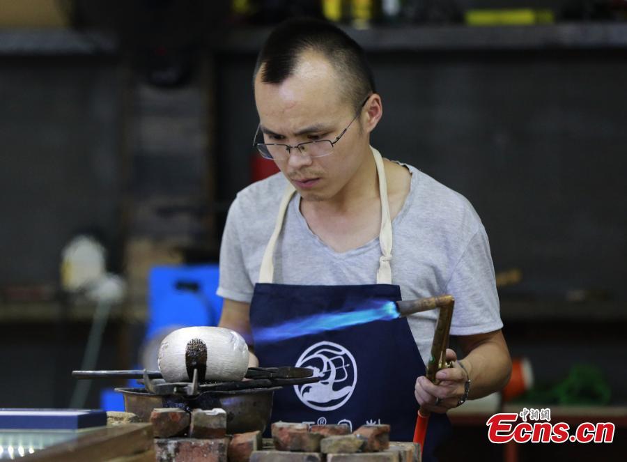 Yang Changgan makes a silver pot in his studio in Zhangjiajie City, Central China’s Hunan Province, Sept. 5, 2018. Yang, born in 1986 in Guizhou Province, was exposed to the craft of silverwork from an early age. After completing his bachelor’s degree at Nanchang Institute of Technology in 2010, he learned with Yang Guangbin, a master crafter of the silver ornaments of the Miao people. He then opened his own studio in Zhangjiajie in 2015, mainly developing silver pot products. Yang said it takes 10-15 days to make a silver pot as the process involves nearly 100 steps, including pounding, refining and wielding. Yang said his creations sell well in nearly 20 countries and regions. (Photo: China News Service/Wu Yongbing)