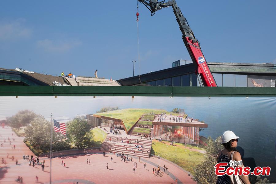 A woman looks at the artist drawing for a new free-standing Statue of Liberty Museum on Liberty Island, Sept. 6, 2018. The existing museum inside The Statue of Liberty can only accommodate a fraction of visitors. The new museum, on track to open in May of 2019, will create three significant gallery spaces. (Photo: China News Service/Liao Pan)