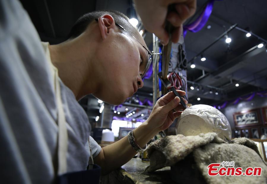 Yang Changgan makes a silver pot in his studio in Zhangjiajie City, Central China’s Hunan Province, Sept. 5, 2018. Yang, born in 1986 in Guizhou Province, was exposed to the craft of silverwork from an early age. After completing his bachelor’s degree at Nanchang Institute of Technology in 2010, he learned with Yang Guangbin, a master crafter of the silver ornaments of the Miao people. He then opened his own studio in Zhangjiajie in 2015, mainly developing silver pot products. Yang said it takes 10-15 days to make a silver pot as the process involves nearly 100 steps, including pounding, refining and wielding. Yang said his creations sell well in nearly 20 countries and regions. (Photo: China News Service/Wu Yongbing)
