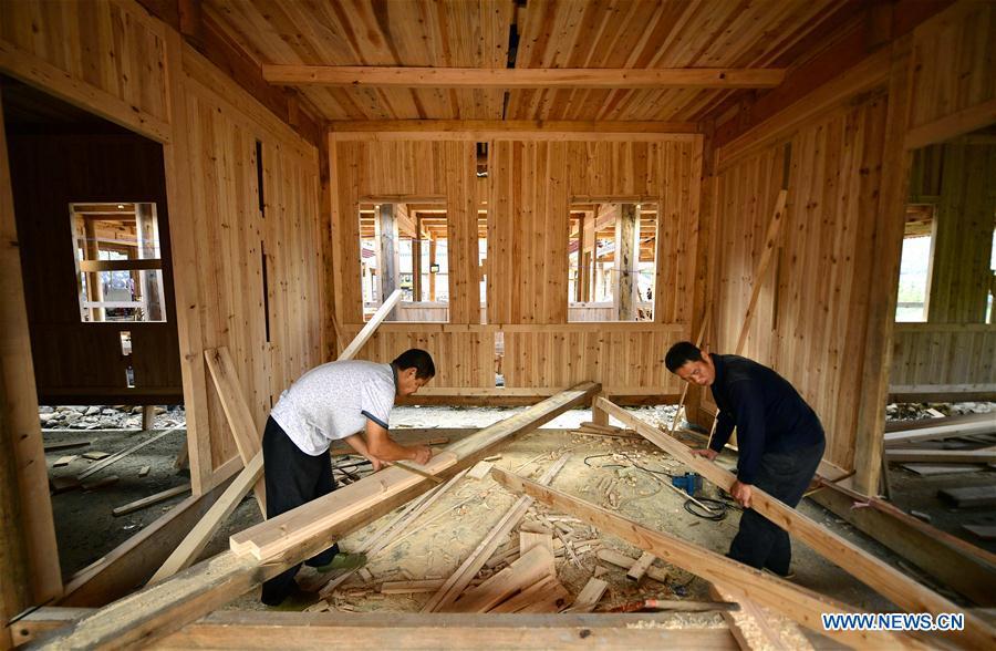 Workers prepare material in the construction site of a Dong ethnic group relocation compound in Yejiaoyuan Village of Xuan\'en County, central China\'s Hubei Province, Sept. 8, 2018. The residence compound, a relocation project aimed at aiding the 40 local families that live under the poverty line, is designed to boost the local tourism as the buildings feature the Dong ethnic group originality that may attract tourists for a culture experience. (Xinhua/Song Wen)