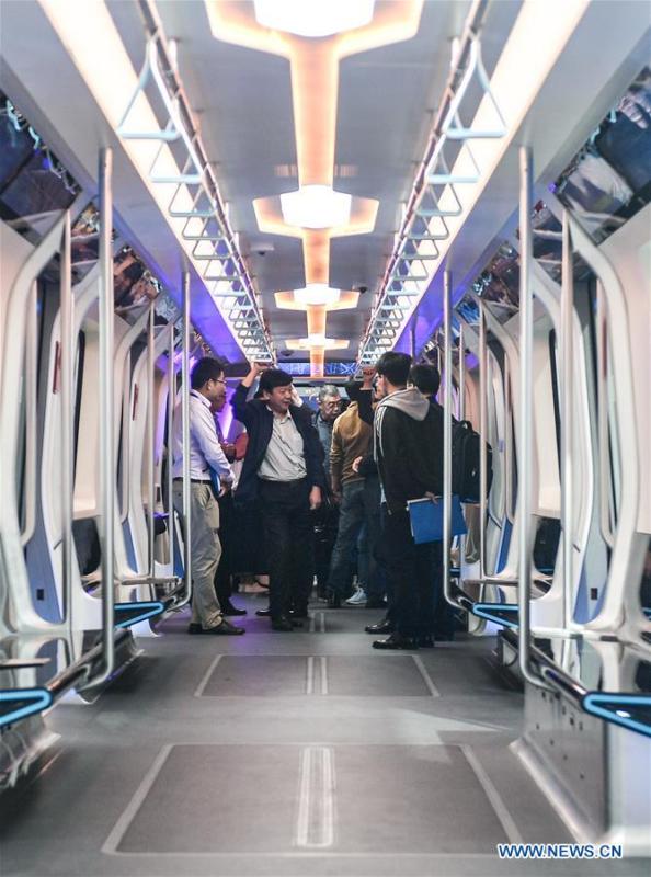 People try out a new-generation carbon-fiber light rail train at an exhibition held in Changchun, capital of northeast China\'s Jilin Province, Sept. 7, 2018. The body of the train is made of carbon fiber composite, making it more energy-efficient, according to its manufacturer CRRC Changchun Railway Vehicles Co., Ltd. (Xinhua/Xu Chang)