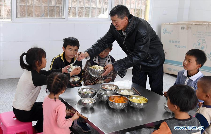 Wang Zhengxiang prepares meals for students at Ayiyang Primary School in Sanmeng Village of Luquan Yi and Miao Autonomous County, southwest China\'s Yunnan Province, Sept. 6, 2018. One teacher, eight students, none was and will be given up thanks to rural teacher Wang Zhengxiang. Wang Zhengxiang of Miao ethnic group, 56, is the only teacher and has been teaching at the remote village primary school of Ayiyang for 38 years. Ayiyang Primary School, lying at an altitude of 2,600 meters above sea level and surrounded by mountains, is not within easy reach of outside world. There are just eight students at the school. Yet Wang takes care of his students with love, consideration and strong sense of responsibility. He buys shoes and daily goods for poverty-stricken students with his own money, and he has tried every means to keep those who wanted to drop out due to economic insufficiency. \