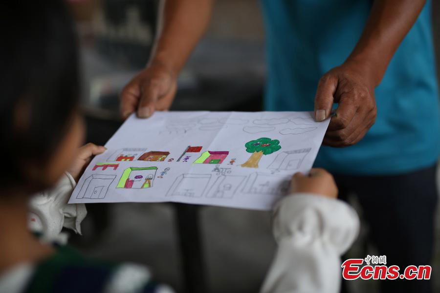 Wang Fangying, a first grader, draws a picture as a gift to teacher Yang Chuangjun ahead of Teacher’s Day at a school in Danggan Village, Paitiao Town, Guizhou Province, Sept. 7, 2018. Yang, 40, is the only teacher in the school that has one first grader and seven pre-school children from nearby villages. If not for the school, children would have to travel to a town more than 20 kilometers away to study. (Photo: China News Service/Huang Xiaohai)