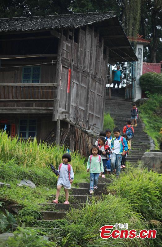 Teacher Yang Changjun sees off students as they leave school in Danggan Village, Paitiao Town, Guizhou Province, Sept. 7, 2018. Yang, 40, is the only teacher in the school that has one first grader and seven pre-school children from nearby villages. If not for the school, children would have to travel to a town more than 20 kilometers away to study. (Photo: China News Service/Huang Xiaohai)