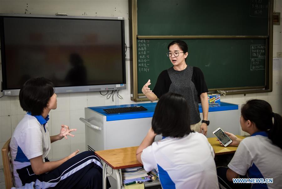 Luo Qianhong, a teacher with Yuanping special school for the disabled students, gestures as she communicates with students in the school in Shenzhen of south China\'s Guangdong Province Sept. 7, 2018. Luo, a hearing-impaired former graduate from the school, began to work as a teacher in the school in 2006 when she finished her university study. Good at communication and willing to help, Luo became popular with hearing-impaired students who distinguished in return with outstanding performances thanks to her influence and encouragement. (Xinhua/Mao Siqian)