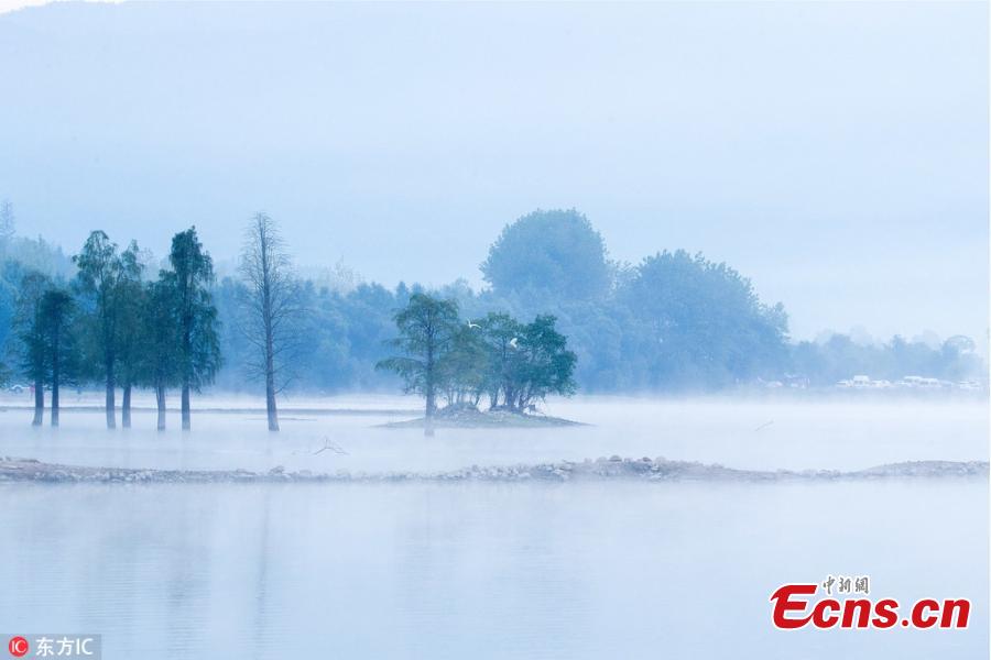Mist drifts over Qishu Lake in Huangshan City in Anhui Province, Sept. 9, 2018. Surrounded by mountains, the lake is located two kilometers east of Hongcun Village, a UNESCO heritage site, and it is a tourist attraction known for its beautiful natural landscape. (Photo/IC)