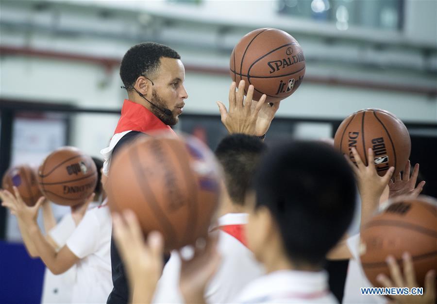 NBA player Stephen Curry of Golden State Warriors takes a training session with young players of Middle School Attached to HUST (Huazhong University of Science and Technology) during his China Tour in Wuhan, central China\'s Hubei Province, Sept. 10, 2018. (Xinhua/Xiao Yijiu)