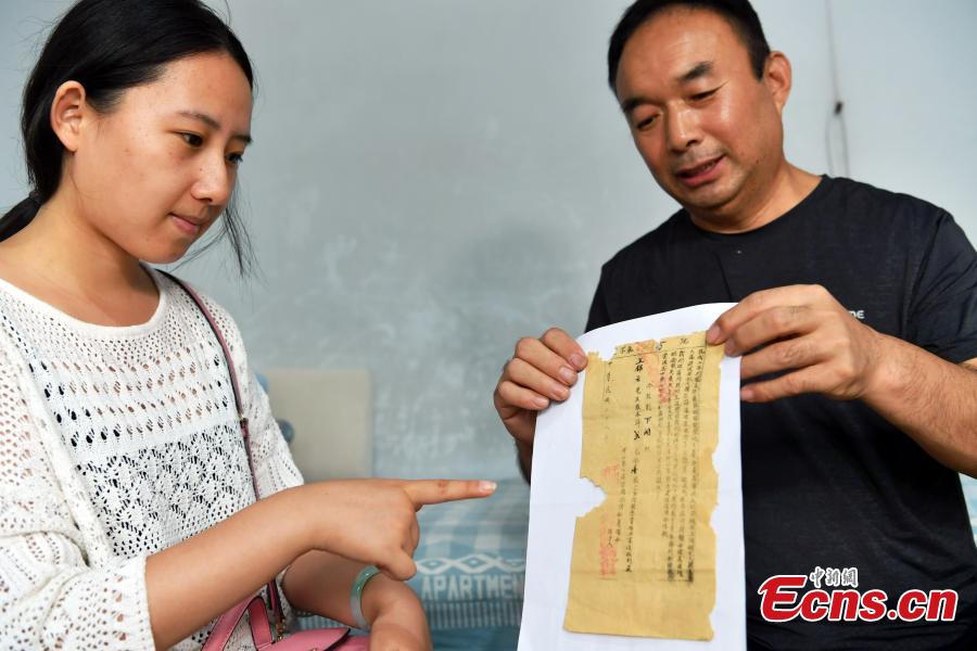 Wang Zhiliang shows a stock certificate issued in 1939 in Xiatan Village, Pingshan County, North China’s Hebei Province, Sept. 11, 2018. Wang said his grandfather, Wang Jinyun, purchased the stock to support the war against Japanese aggression in 1939, issued by the local government of the time. (Photo: China News Service/Zhai Yujia)