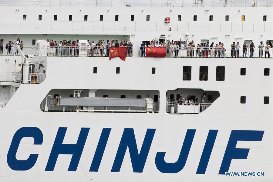 Chinese passengers wave goodbye as the ferry \