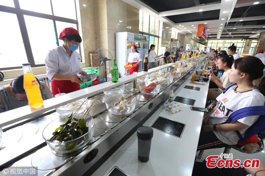 Photo taken on Sept. 12, 2018 shows a hot pot canteen at the Chang\'an Campus of Xi\'an University of Finance and Economics in Xi’an City, Northwest China’s Shaanxi Province. The canteen became popular among students for its rotary belt that delivers fresh, cheap ingredients and a variety of flavors. A student said spending 20 yuan can could get a good treat. (Photo/VCG)