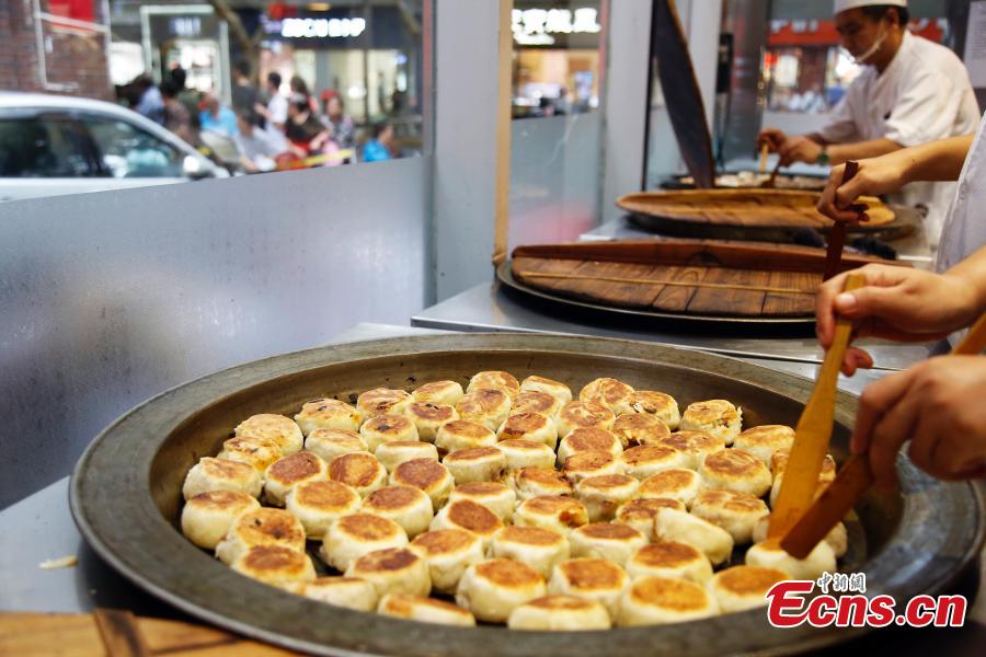 Customers queue to buy mooncakes for the upcoming Mid-Autumn Festival at a time-honored store in Shanghai, Sept. 12, 2018. The joyous Mid-Autumn Festival is celebrated on the fifteenth day of the eighth moon, Sept. 24 this year. Mooncakes are usually made with sweet fillings, such as nuts, mashed red beans, lotus-seed paste or Chinese dates, wrapped in a pastry. But the Shanghai store offers mooncakes with meat fillings, which prove to be very popular. (Photo: China News Service/Tang Yanjun)