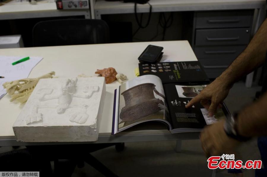 <?php echo strip_tags(addslashes(Jorge Lopes, researcher at the Pontifical Catholic University, shows a book with pictures of originals and replicas of some of the artifacts that were inside the National Museum, in Rio de Janeiro, Brazil, Sept. 5, 2018. About 300 pieces of the Brazil's National Museum that were scanned and some printed in 3D could help to rebuild part of the heritage lost in the fire this weekend. Since 2000, researchers at the PUC worked together with the museum, scanning and printing some of the most important objects of the institution. (Photo/Agencies))) ?>