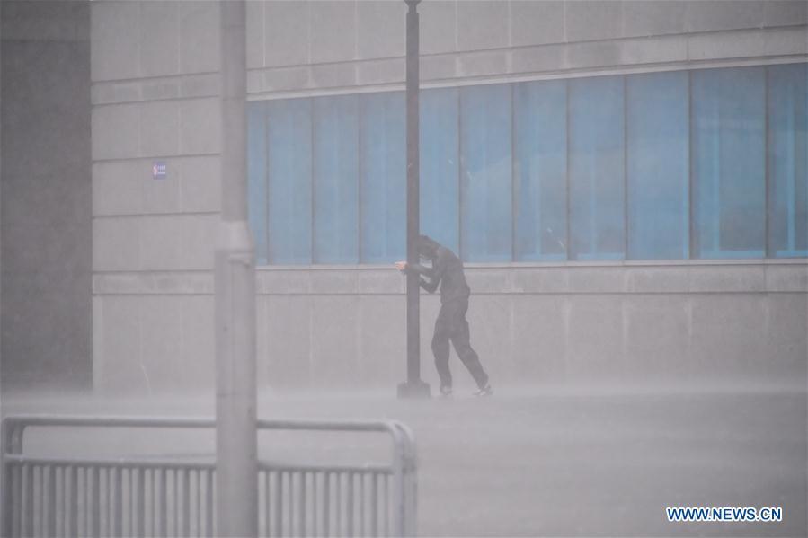 A pedestrian walks against storm in Hong Kong, south China, Sept. 16, 2018. Hurricane Signal No. 10, the top level warning, was issued by the Hong Kong Observatory at 9:40 a.m. local time on Sunday, and was replaced by the second highest warning Southeast Gale Signal 8 at 7:40 p.m. local time. (Xinhua/Lui Siu Wai)