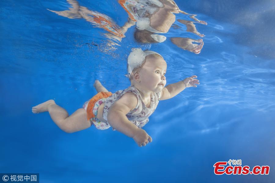 A baby girl swims underwater in a pool in Odessa, Ukraine. (Photo/VCG)
