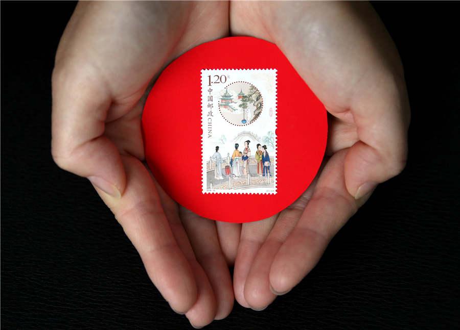 A stamp collector shows the newly issued stamp themed on the Mid-Autumn Festival, in Zaozhuang city, Shandong Province, Sept. 15, 2018. (Photo/Asianewsphoto)