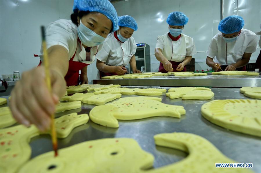 Staff make traditional moon cakes at a food processing workshop in Zhangye, northwest China\'s Gansu Province, on Sept. 18, 2018. Making traditional moon cakes before the Mid-Autumn Festival dates back to a thousand years in Zhangye. (Xinhua/Wang Jiang)